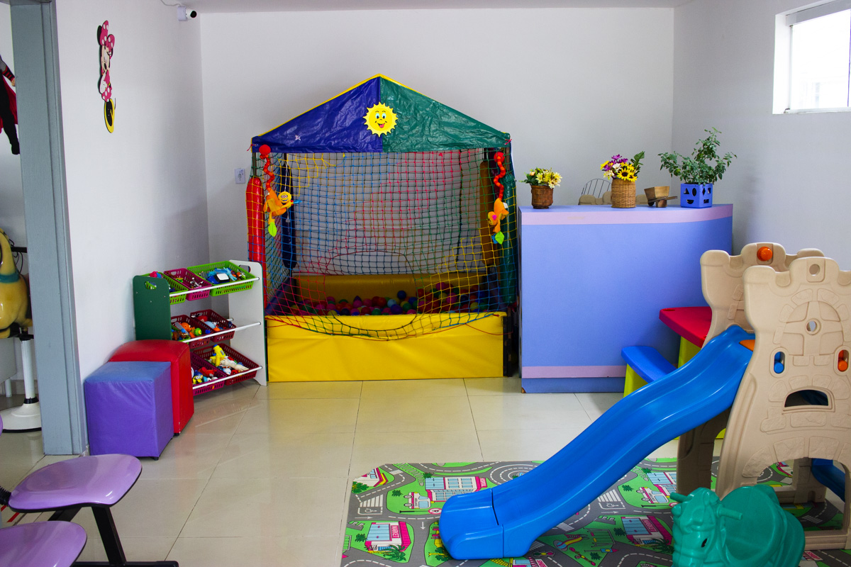 Cantinho de brincar com piscina de bolinhas, escorregador azul e tapete de brinquedo